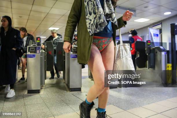 Participant takes part in the annual "No Trousers Tube Ride" event as she walks past the ticket machines at King's Cross station in London. During...