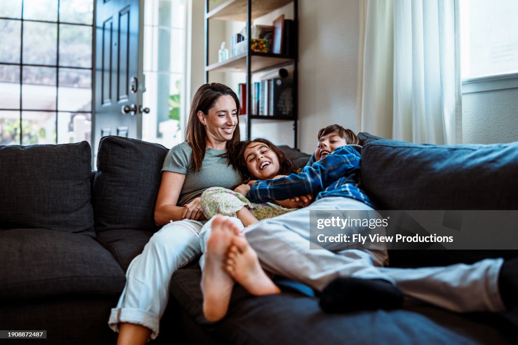 Playful kids on the couch with their mom