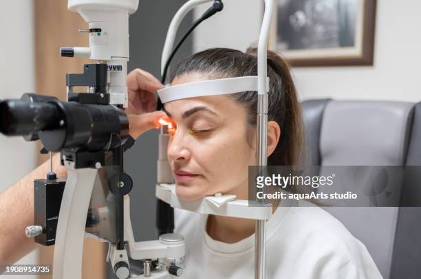 ophthalmologist examining female patient eye with a slit lamp at clinic - eye problems stock pictures, royalty-free photos & images