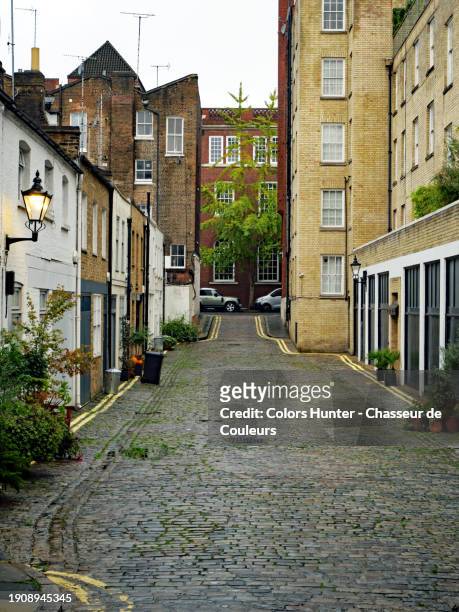a cobbled street with terraced houses and residential buildings in london, england, united kingdom. no people. - cobblestone floor stock pictures, royalty-free photos & images