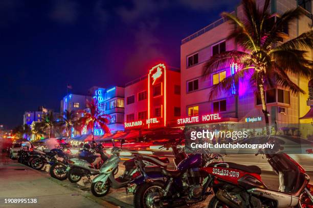 les gens apprécient les palmiers et les hôtels art déco à ocean drive la nuit - panoramisch photos et images de collection