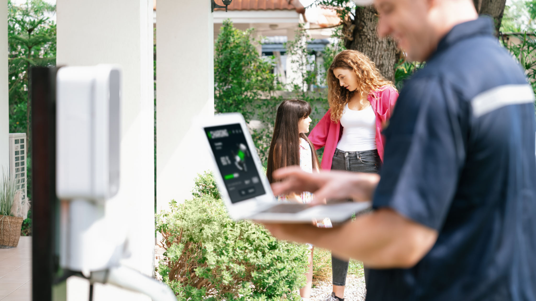 Qualified technician working with laptop for home EV station. Synchronos Qualified technician working with laptop for home EV station. Synchronos