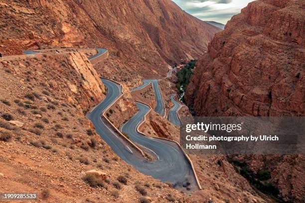 high angle view of winding road on mountain slope dades valley, morocco - wonderlust stock-fotos und bilder