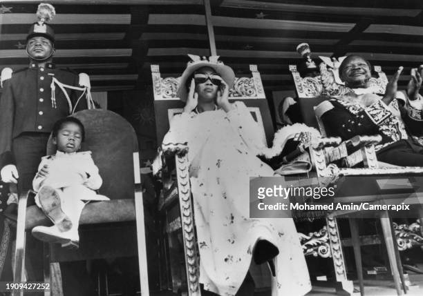 Central African Royals Crown Prince Bokassa Jr sits sleeping in the chair alongside his mother, Empress Catherine, and father Bokassa I as they watch...