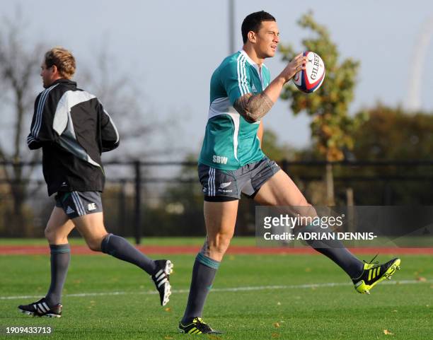 New Zealand's Sonny Bill Williams runs with the ball past Andrew Ellis during a training session at Harrow School playing fields in Harrow November...