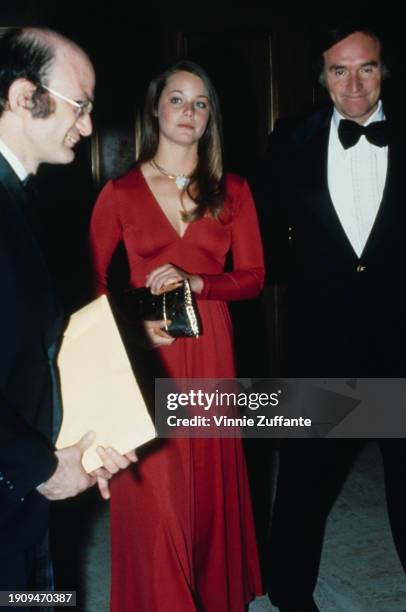 American actress Susan Dey, wearing a full-length long-sleeved dress, holding a gold purse, and American talent manager Lenny Hirshan, who wears a...