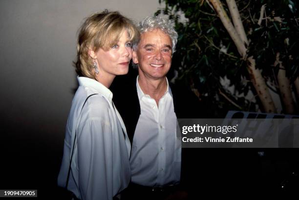 American actress Susan Dey, wearing a white shirt, with a black shoulder strap over her right shoulder, and pendant earrings, with her husband,...