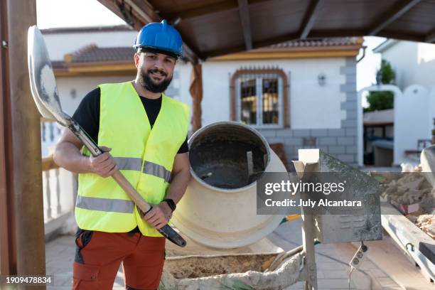 40-jähriger bauarbeiter renoviert ein haus auf einer außenterrasse - betonmischmaschine stock-fotos und bilder