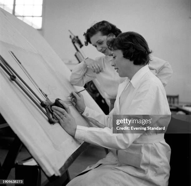 Two women designers working in the drawing office of Vauxhall Motors in Luton, Bedfordshire, March 11th 1957.