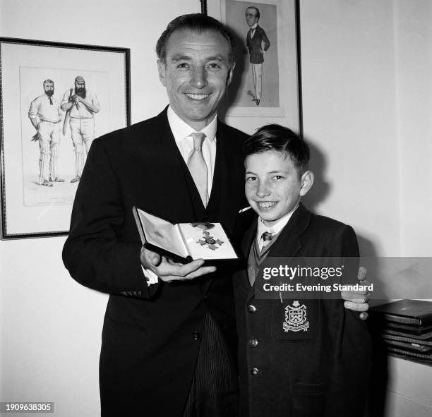 English footballer Stanley Matthews with his son Stanley Jr after being awarded a CBE at an investiture ceremony at Buckingham Palace in London,...