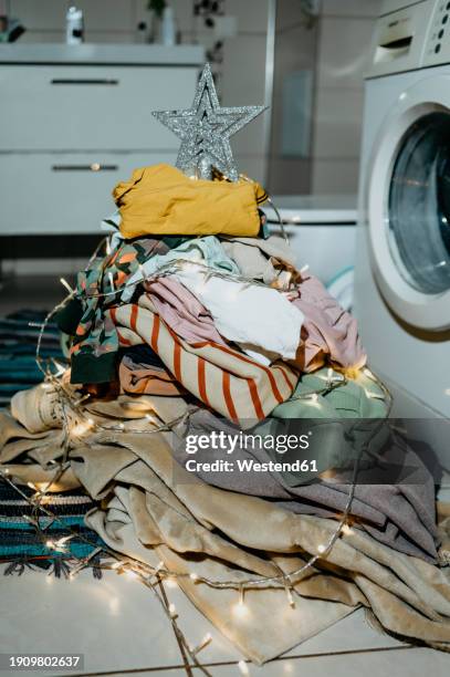 christmas tree made from heap of laundry clothes near washing machine - machine christmas tree stock pictures, royalty-free photos & images