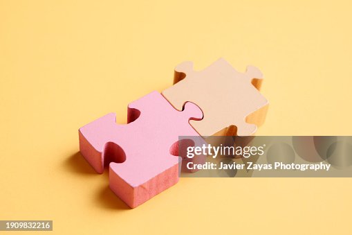 Two Puzzle Pieces on Yellow Background Two Puzzle Pieces on Yellow Background