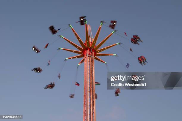 germany, lower saxony, meppen, chain swing ride spinning against clear sky at dusk - spinning stock pictures, royalty-free photos & images