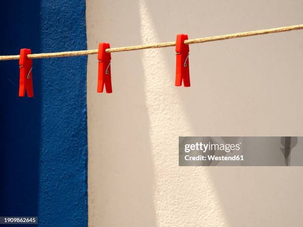 clothespins hanging on empty clothesline - clothespin stock pictures, royalty-free photos & images