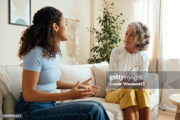 patient gesturing and talking to therapist at home - psychosoziale beratung stock-fotos und bilder