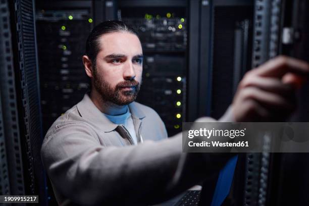 young engineer working in server room - computer mainframe stock pictures, royalty-free photos & images