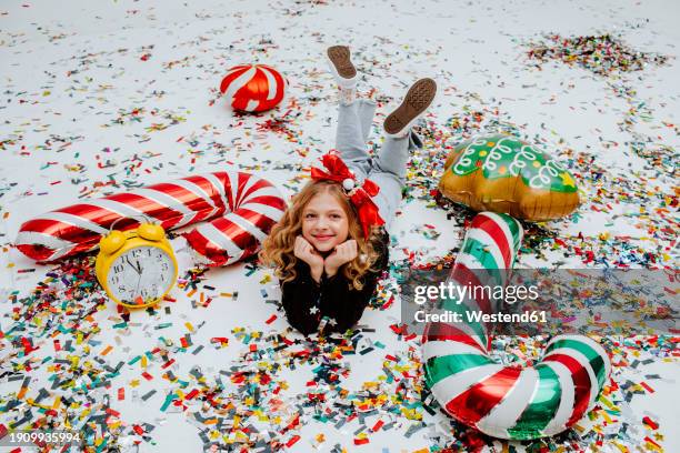 smiling girl lying on confetti near christmas decoration - candy cane stock pictures, royalty-free photos & images