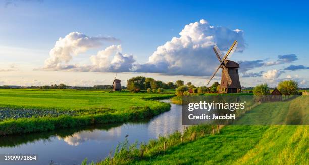 dutch windmill along a  canal near schermerhorn, netherlands - wasserrad stock-fotos und bilder