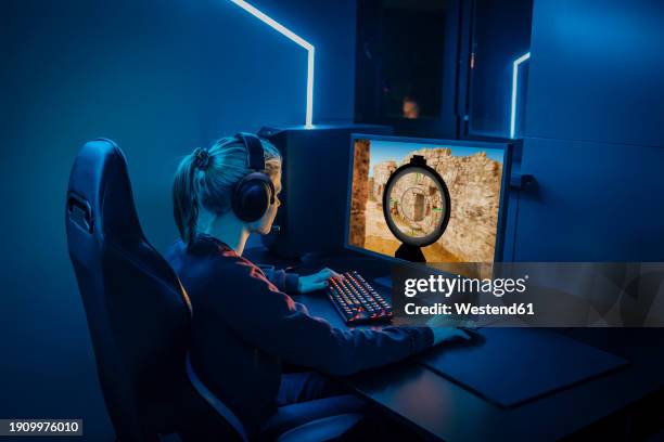 professional gamer wearing headphones and playing game on computer - joueur de jeux informatiques photos et images de collection