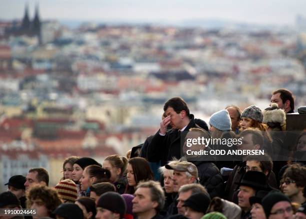 Man reacts as he stands among people paying their last respect as they watch the horse drawn hearse carrying the flag draped coffin of former Czech...