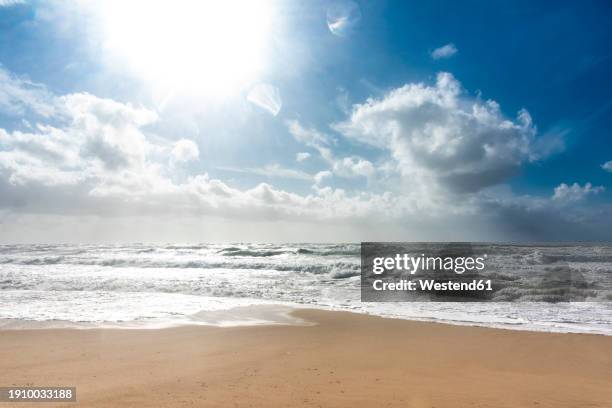 germany, schleswig-holstein, sun shining over sandy beach on sylt island - noordzee stockfoto's en -beelden