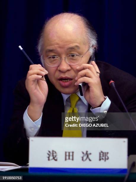 Japanese novelist Jiro Asada talks on a mobile phone at the end of a press conference for the Japan-China Friendship Committee for the 21st Century...