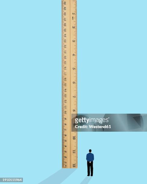 ilustrações, clipart, desenhos animados e ícones de man standing near oversized ruler against blue background - measuring height