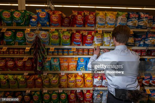 Worker arranges Lay's chips at an Albertsons Cos. Brand Safeway grocery store in Scottsdale, Arizona, US, on Wednesday, Jan. 3, 2024. Albertsons Cos....