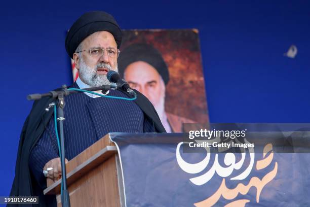 Iranian President Ebrahim Raisi speaks during the funeral ceremony for victims of twin explosions near the cemetery where the grave of Iran's former...