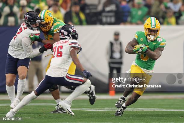 Running back Bucky Irving of the Oregon Ducks rushes the football against the Liberty Flames during the second half of the Fiesta Bowl at State Farm...