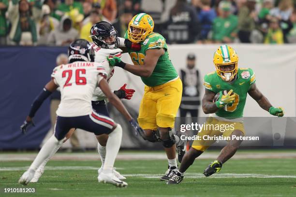 Running back Bucky Irving of the Oregon Ducks rushes the football against the Liberty Flames during the second half of the Fiesta Bowl at State Farm...