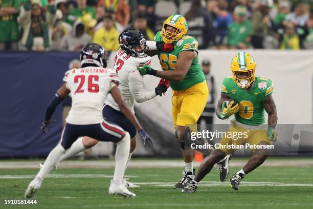 Running back Bucky Irving of the Oregon Ducks rushes the football against the Liberty Flames during the second half of the Fiesta Bowl at State Farm...