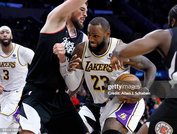 Los Angeles, CA Lakers forward LeBron James, #23, center, drives to the hoop as Clippers guard James Harden, #1, right, and Clippers center Ivica...