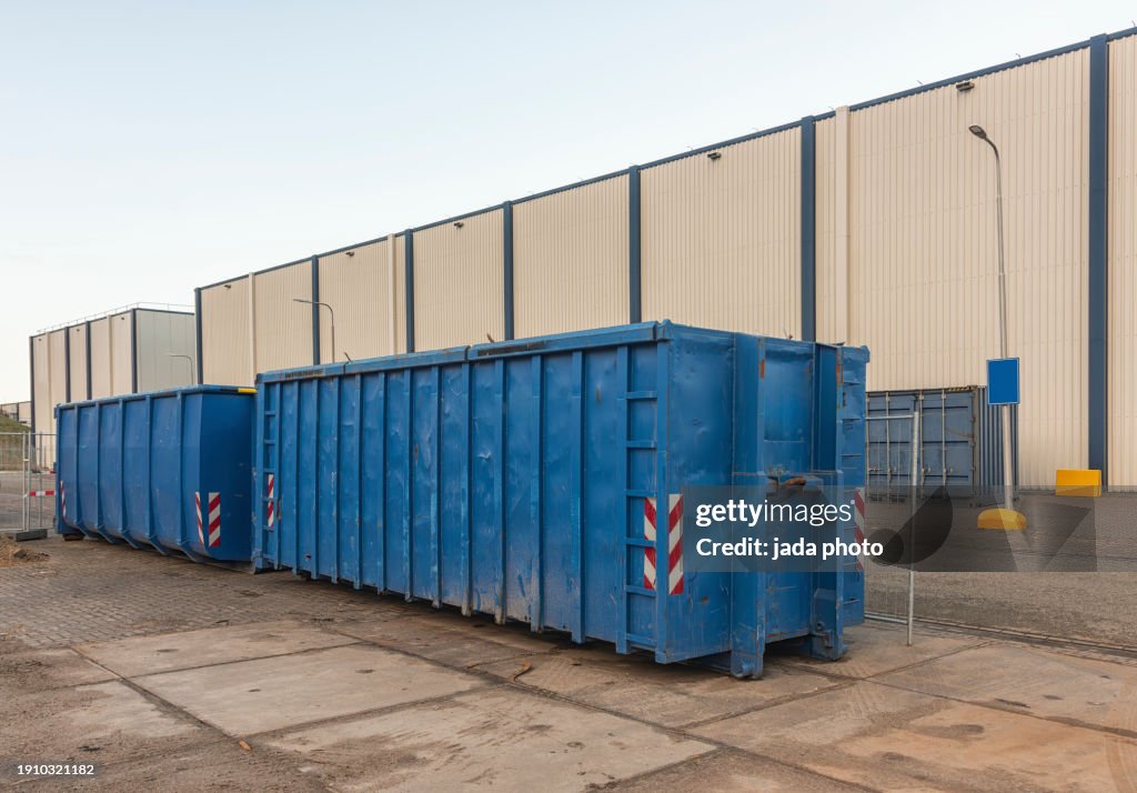 Two blue steel industrial waste containers