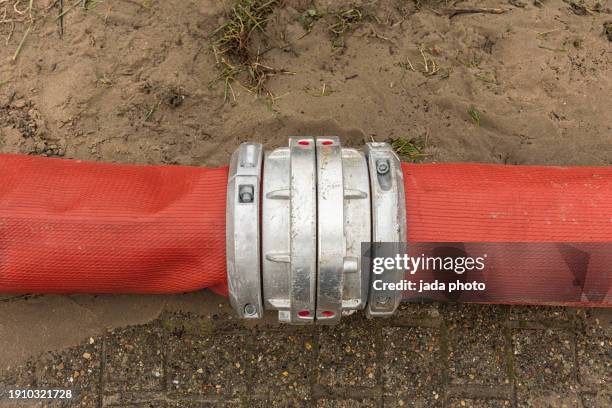 two red fire hoses with a 205 mm connection piece - feuerwehrschlauch stock-fotos und bilder
