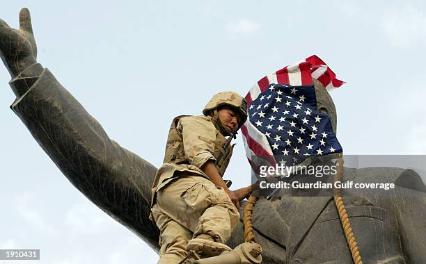 Marines attach a line before pulling down a statue of Saddam Hussein in the centre of Baghdad.