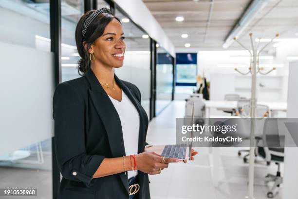 smiling latina businesswoman holding laptop at work hub - best execution stock pictures, royalty-free photos & images