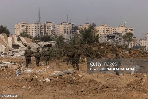This picture taken during a media tour organised by the Israeli military on January 8 shows troops operating in the area of al-Bureij in the central...