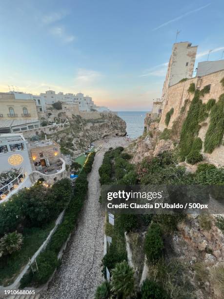 high angle view of buildings by sea against sky,polignano a mare,puglia,italy - bari italy stockfoto's en -beelden