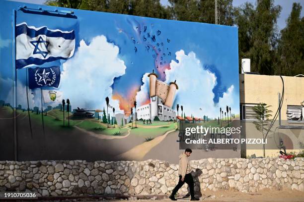 Man walks past the Sderot police station that was attacked by Hamas militants on October 7, in the southern Israeli city of Sderot near the Gaza...