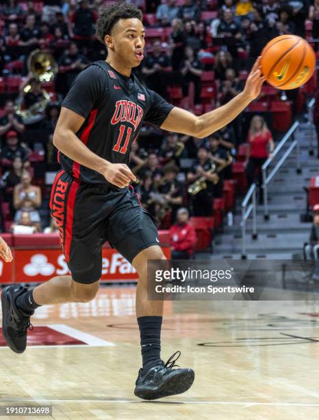 Guard Dedan Thomas Jr. Passes the ball in the first half of a college basketball game between the UNLV Runnin' Rebels and the San Diego State Aztecs,...