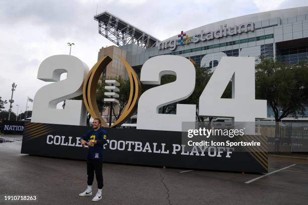 A Michigan fan takes a photo in front of the 2024 CFB logo before the College Football Playoffs National Championship game Michigan Wolverines and...