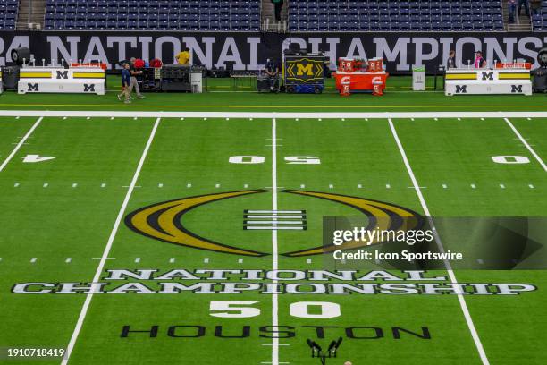 The CFB National Championship logo is set midfield before the College Football Playoffs National Championship game Michigan Wolverines and Washington...