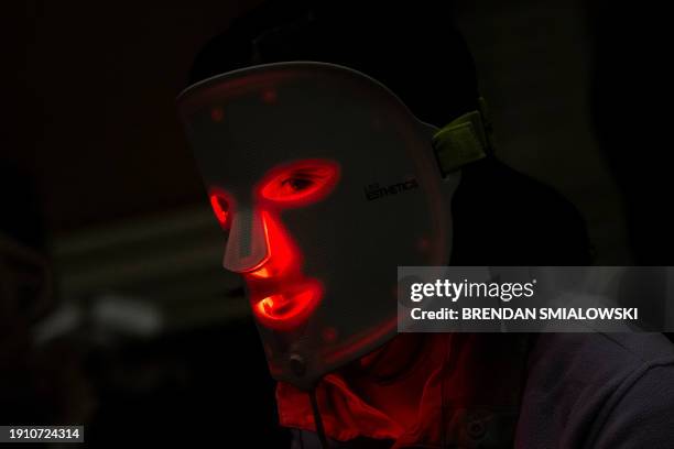 Person wears a red light mask from Light Tree Ventures during Pepcom's Digital Experience at the The Mirage resort during the Consumer Electronics...