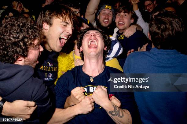 From left, Michigan Wolverines students Xander Caruana, Alex Melnyk and James Kolasinski react while watching the 2024 College Football Playoff...