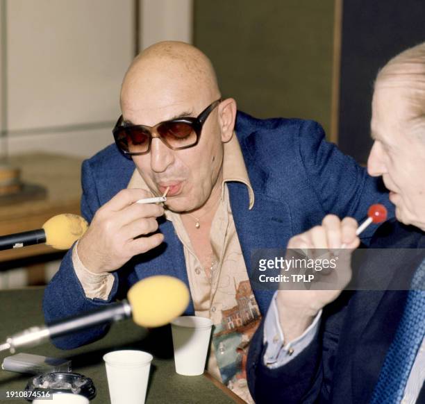 Greek American actor Telly Savalas sucks on a lollipop during a press conference in London, England, November 10, 1975.