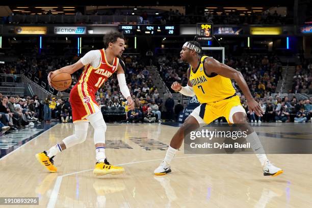 Trae Young of the Atlanta Hawks dribbles the ball while being guarded by Buddy Hield of the Indiana Pacers in the second quarter at Gainbridge...