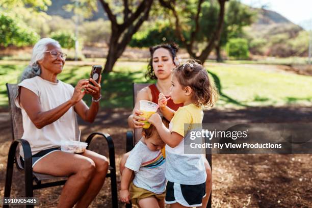 la nonna scatta una foto del bambino che beve frullato - popolo eurasiatico foto e immagini stock