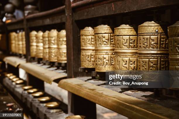rows of bronze prayer wheel in golden temple in patan, nepal. - tibetansk buddhism bildbanksfoton och bilder