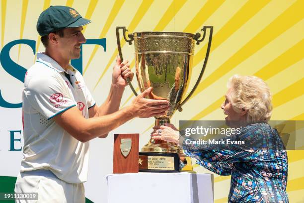 Pat Cummins of Australia is presented with the Benaud-Qadir Trophy by Daphne Benaud after winning the series against Pakistan during day four of the...